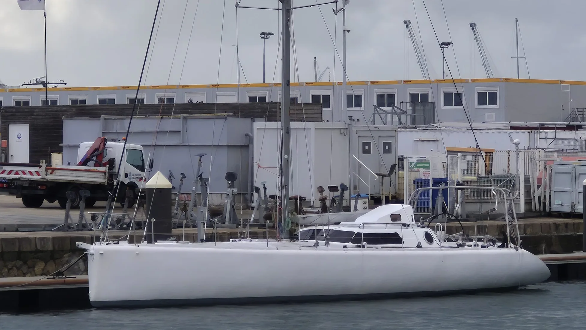 Tagaroa de profil le long du quai : longue coque aluminium basse avec un petit rouf à l’arrière