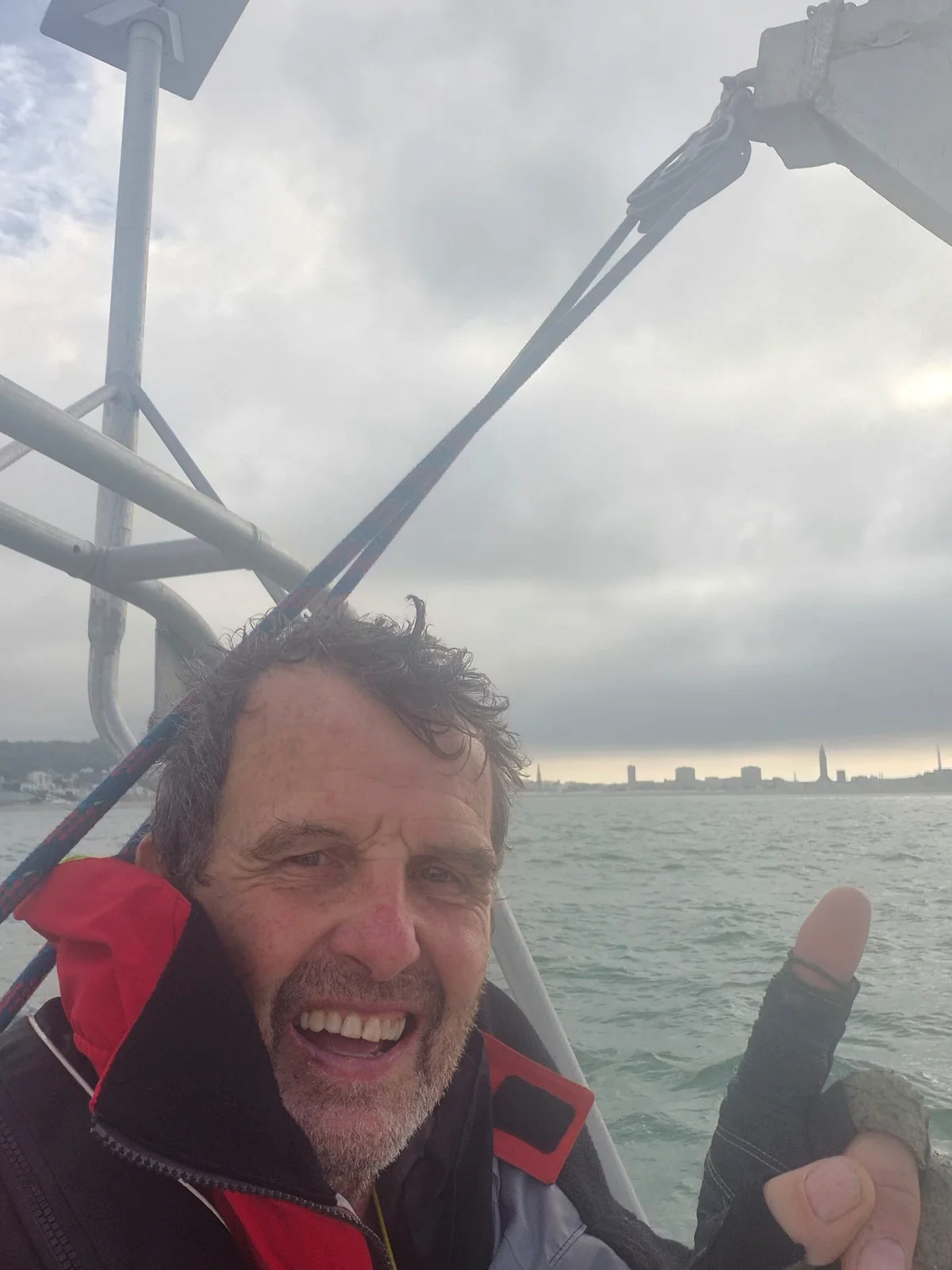 Amaury lève le pouce, la ville derrière lui