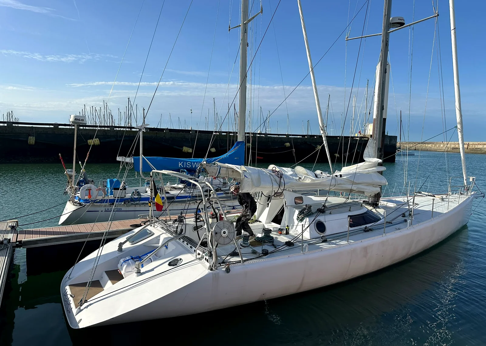 Tagaroa amarré au ponton du Havre, lumière du matin sur la coque, la digue en arrière-plan