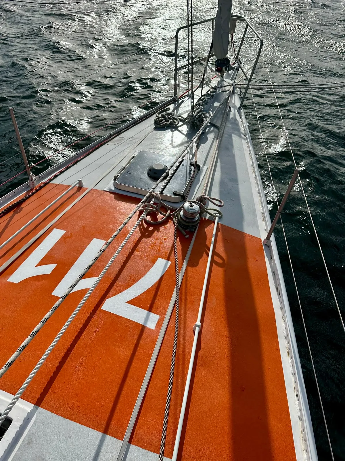 Le pont avant orange de Tagaroa avec le numéro 711, la mer scintille à côté