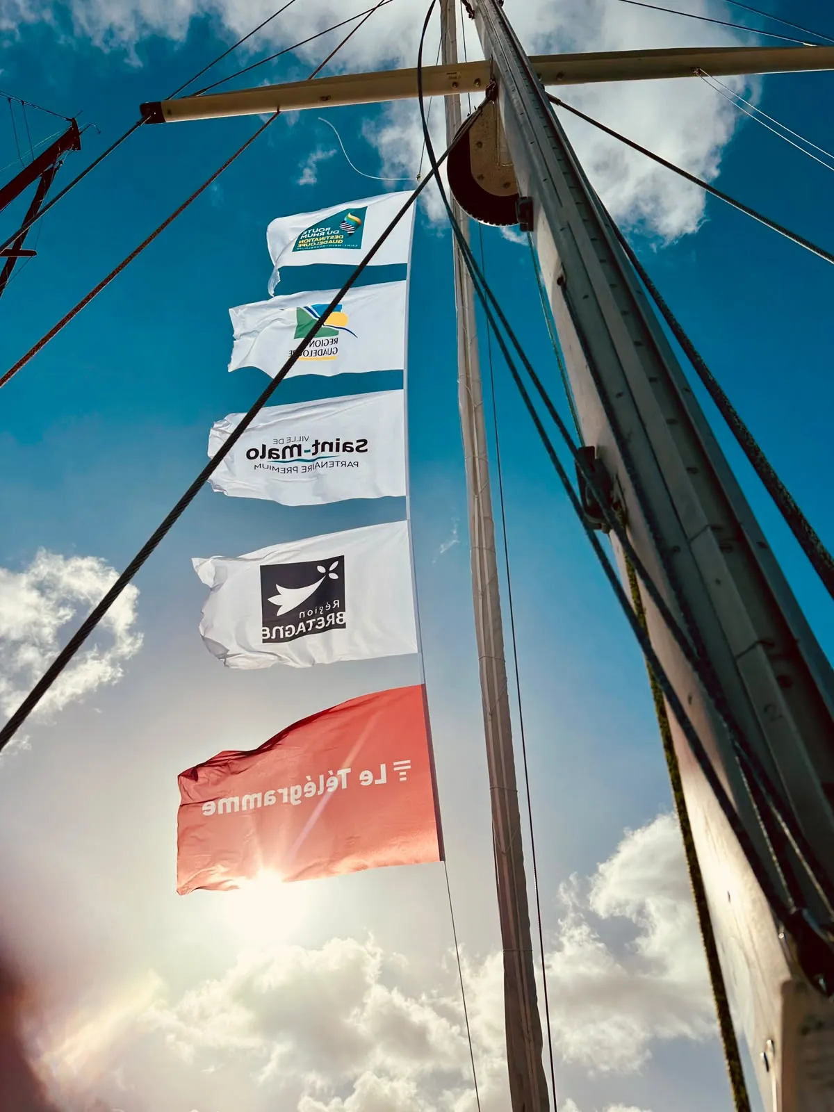 Les pavillons de la Route du Rhum, de la Guadeloupe, de Saint-Malo, de la Bretagne et du Télégramme dans le mât