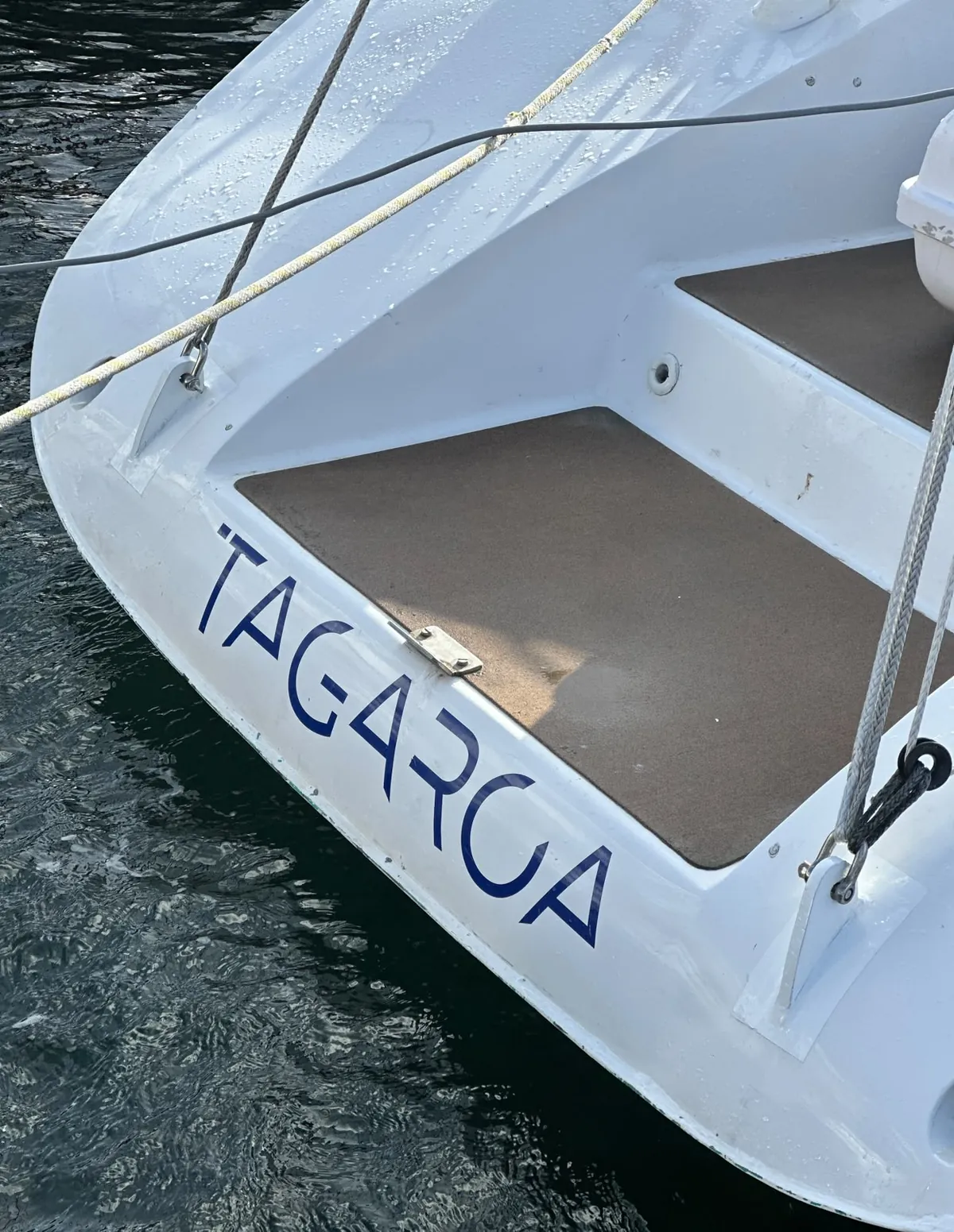 Le nom Tagaroa sur le tableau arrière du bateau, au-dessus de l’eau du port