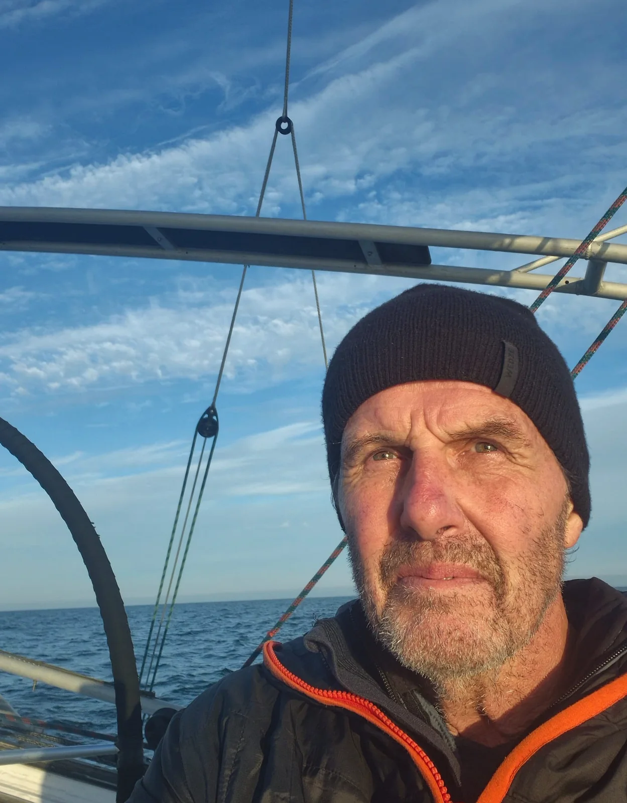 Amaury seul sur le pont au large, bonnet sur la tête, dans une lumière rasante