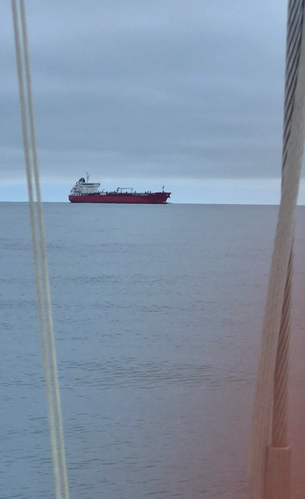 Un tanker à l’horizon, vu entre les haubans