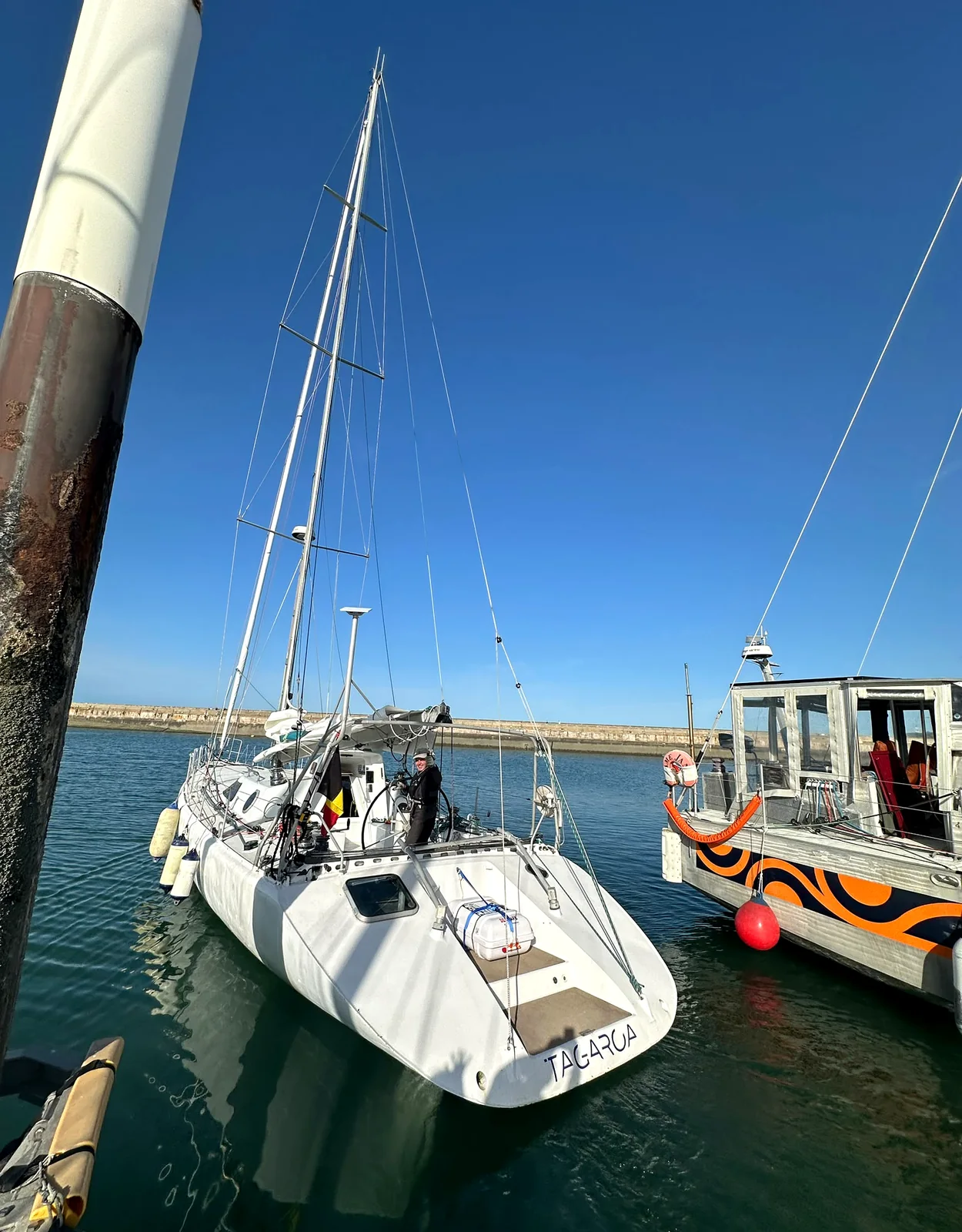 Tagaroa quitte le port, derrière un petit bateau de servitude